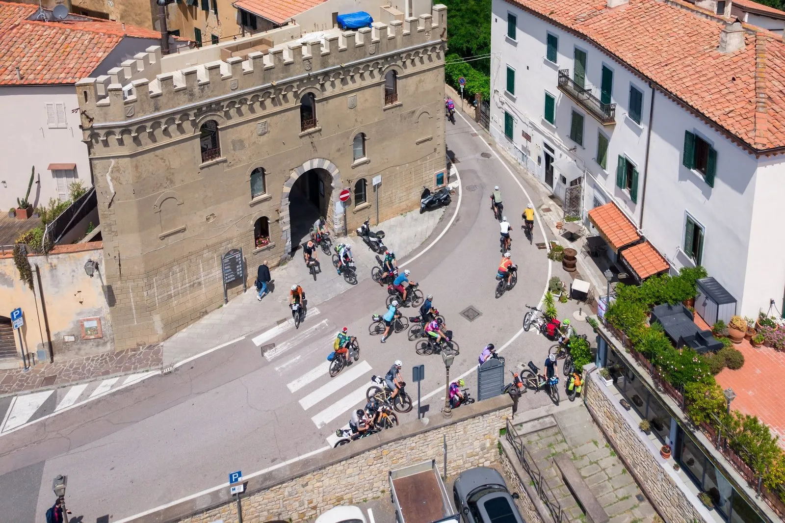 Il gruppo del Tuscany Trail entra a Campiglia Marittima dalla porta del borgo, visto dal drone